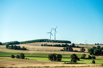 Wind turbines in rural agricultural landscape, sustainable energy production, renewable energy