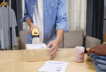 Asian man business owner scanning barcode on delivery parcel.