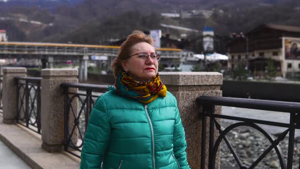 Woman in Middleage is Walking Outdoors in City