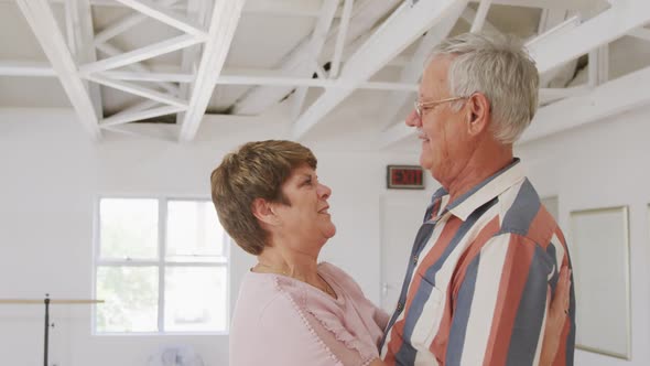 Caucasian senior couple spending time together in a ballroom taking part in dancing class