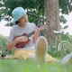 Beautiful Asian teenage girl playing at ukulele in the park, Slow motion - VideoHive Item for Sale