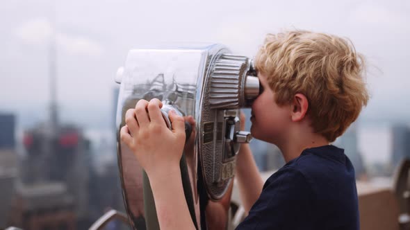 Boy Looking Through Telescope To View New York Skyscrapers