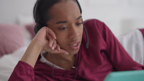 Closeup Portrait of Gorgeous Confident Young African American Woman in Headphones Talking at Tablet