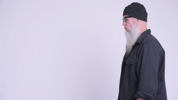 Profile View of Mature Bearded Hipster Man Removing Sunglasses and Looking at Camera