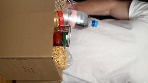 Volunteer Putting Food in a Donation Box. Charity Concept