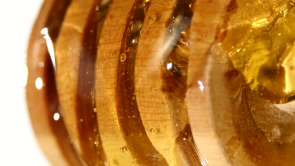 Honey Dripping From a Wooden Spoon, on White, Close Up