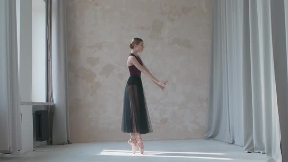 Young Ballerina in a Black Transparent Skirttraining in the Studio Loft Style Standing By the Window