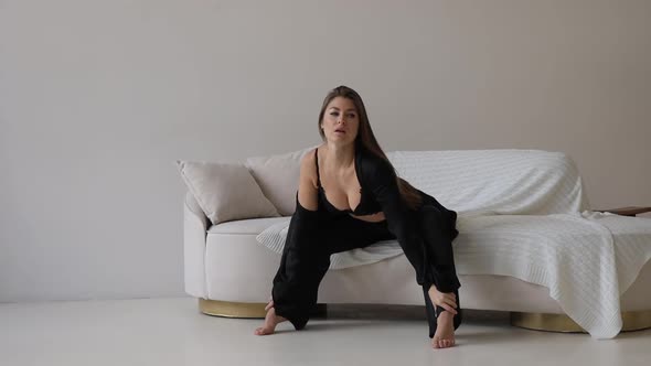 Seductive Woman in Black Underwear Sitting on Sofa