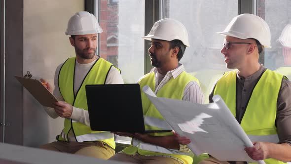 Male Architects in Helmets with Laptop at Office