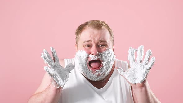 Upset Plump Man in White Undershirt with Foam on Beard, Feels Pain or Irritation, Slow Motion