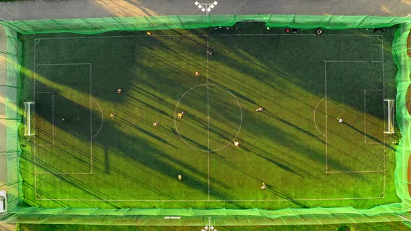 Aerial view of a sports field with footballers playing in spring, Poland alt