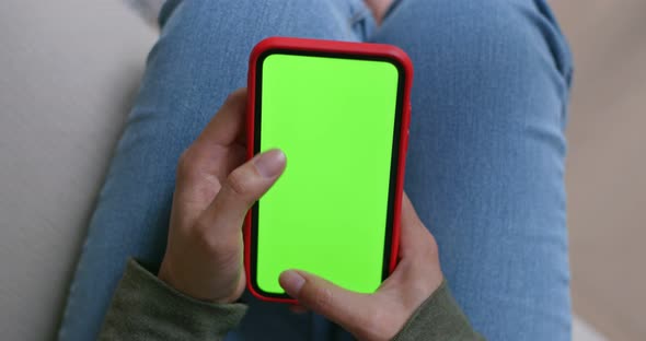 Woman hold with green screen of cellphone at home