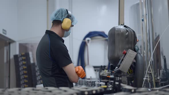 Person Monitoring Production Of Canned Beer In A Factory  Close Up Shot