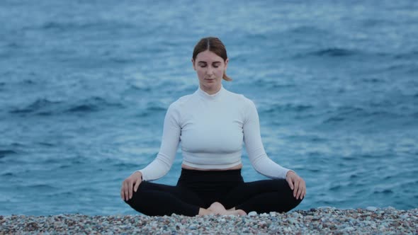 Sports Outdoors  a Woman Doing Yoga and Breathing Exercises By the Blue Sea