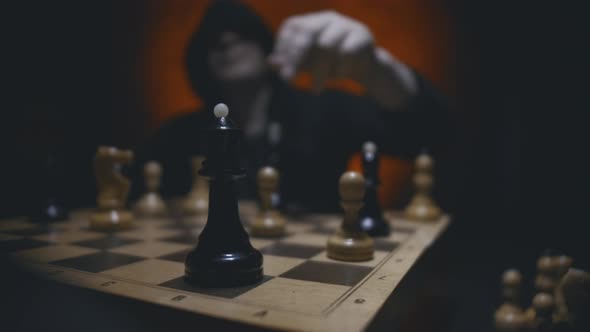 Man in Hoodie Playing Chess Black Figures Win Checkmate Black Queen Defeating White King 