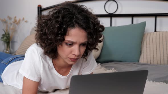 Focused Hispanic Curly Woman Student Study Uses Laptop Distance Education