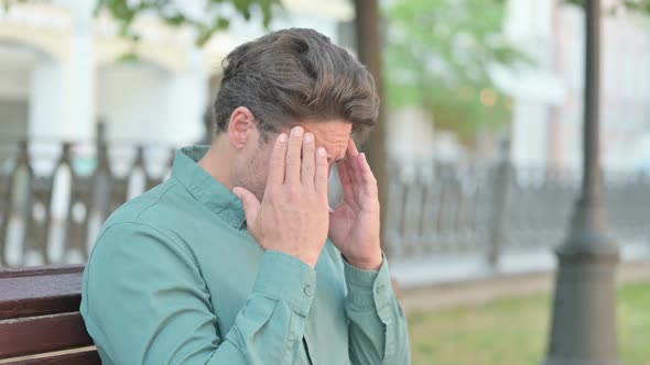 Portrait of Man having Headache on Bench