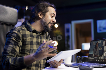 Man grasps notebook while on video call