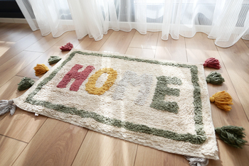 a rug with the word home written on it is on the floor in a hallway