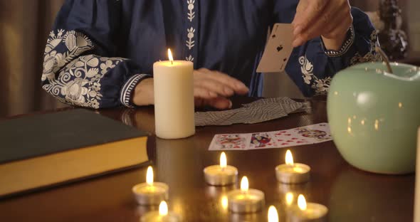 Unrecognizable Mature Caucasian Woman Taking Out Ace of Spades and Putting It To Other Cards Lying