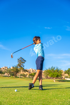 Boy performing perfect swing in a golf course