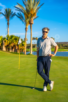 Portrait of a golfer standing on a green course