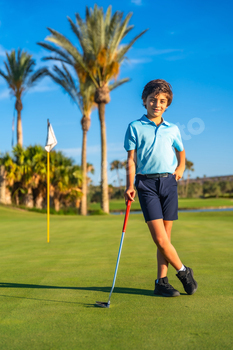 Portrait of a boy with golf club standing on course