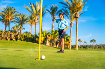 Boy celebrating he scores in a golf course