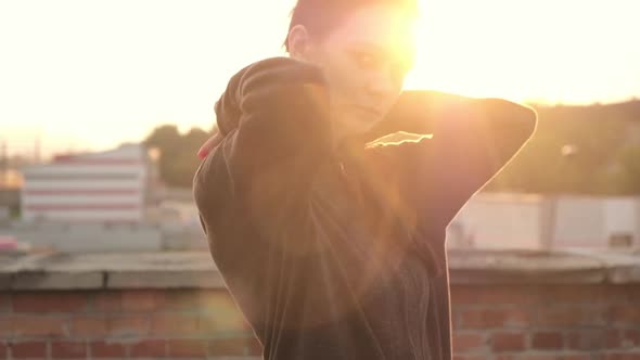 Portrait of beautiful  athletic female boxer puts on hood before exercises