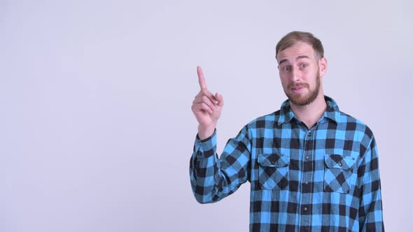 Happy Bearded Hipster Man Pointing Up and Giving Thumbs Up