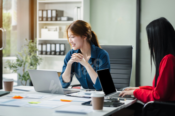 Business woman and partner using calculator and laptop for calculation finance, tax, accounting