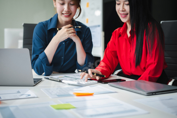 Business woman and partner using calculator and laptop for calculation finance, tax, accounting