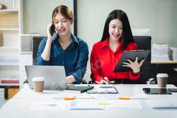 Businesswomen working with tablet and using a calculator to calculate the tax of static