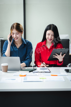 Businesswomen working with tablet and using a calculator to calculate the tax of static