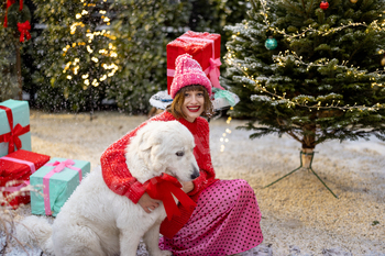 Woman with dog celebrates winter holidays