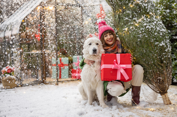 Woman with dog celebrates winter holidays