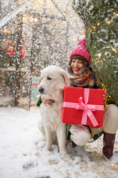 Woman with dog celebrates winter holidays