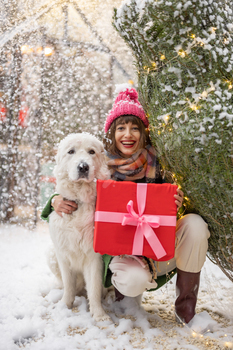 Woman with dog celebrates winter holidays