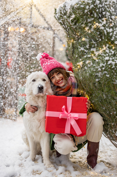 Woman with dog celebrates winter holidays