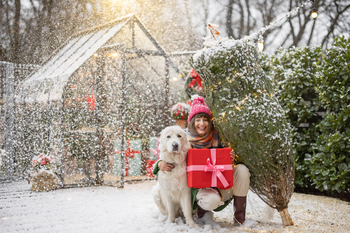 Woman with dog celebrates winter holidays