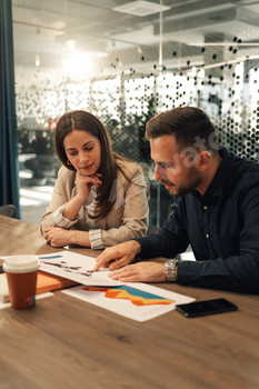 Marketing experts analyzing global market and charts at boardroom.