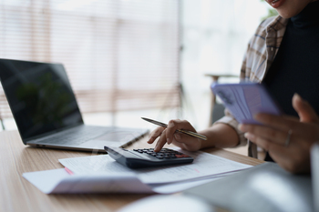 Smart Mortgage Planning woman using a calculator to make Calculations and Consideration