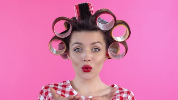 Woman in Hair Rollers Blowing Kiss