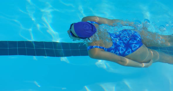 Young female swimmer swimming inside pool 4k