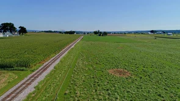 Aerial View of Rich Farmlands and Corn Fields Along a Single Railroad Track