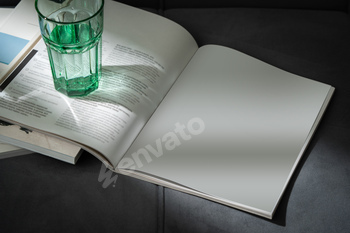 Glass of Water on Open Magazines Resting on a Couch