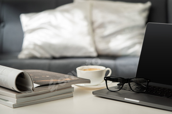 Modern Workspace With Laptop, Glasses, and Magazines