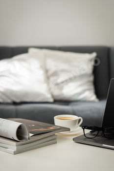 Modern Workspace With Laptop, Glasses, and Magazines