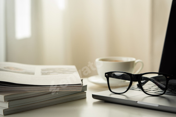 Modern Workspace With Laptop, Glasses, and Magazines