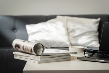 Modern Workspace With Laptop, Glasses, and Magazines